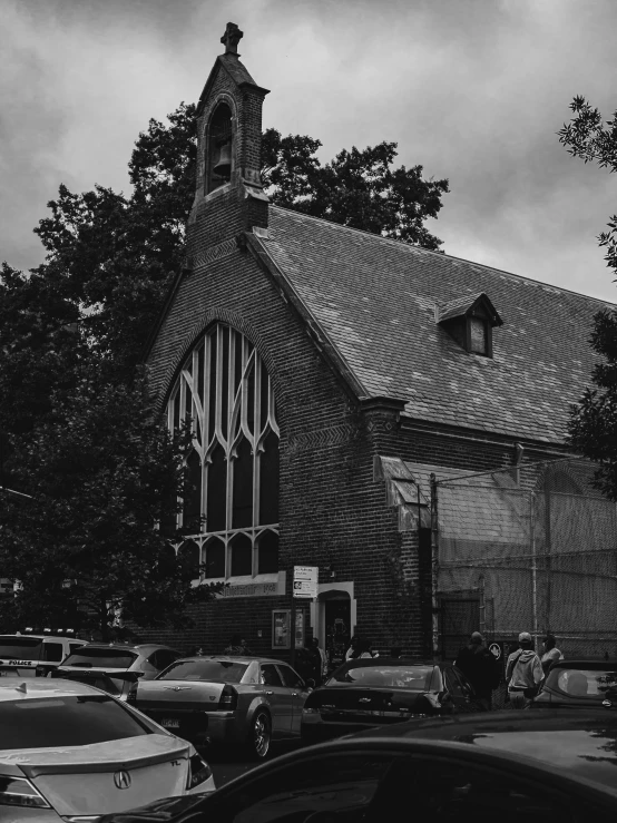 a church with cars parked in the lot next to it