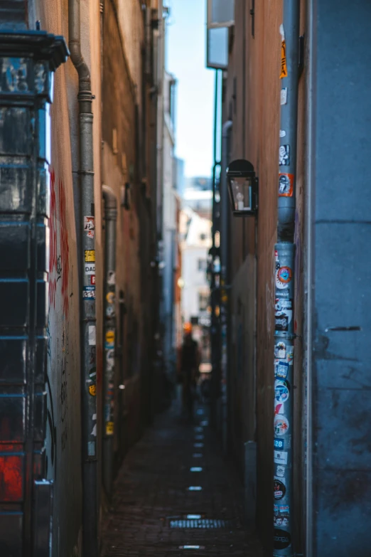 a narrow alley is lined with lots of posters and papers