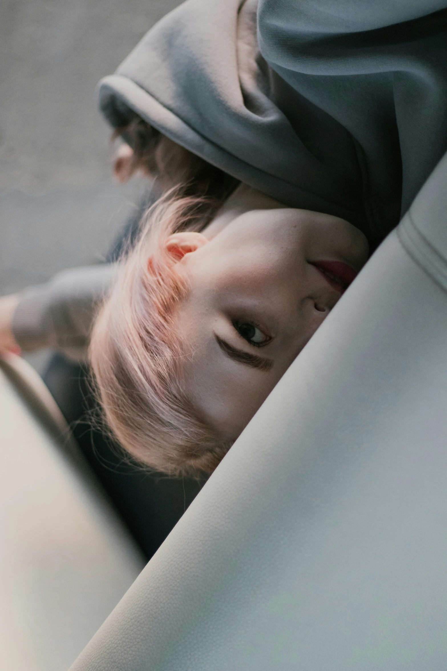 a  leaning over her seat with a sheet on her head