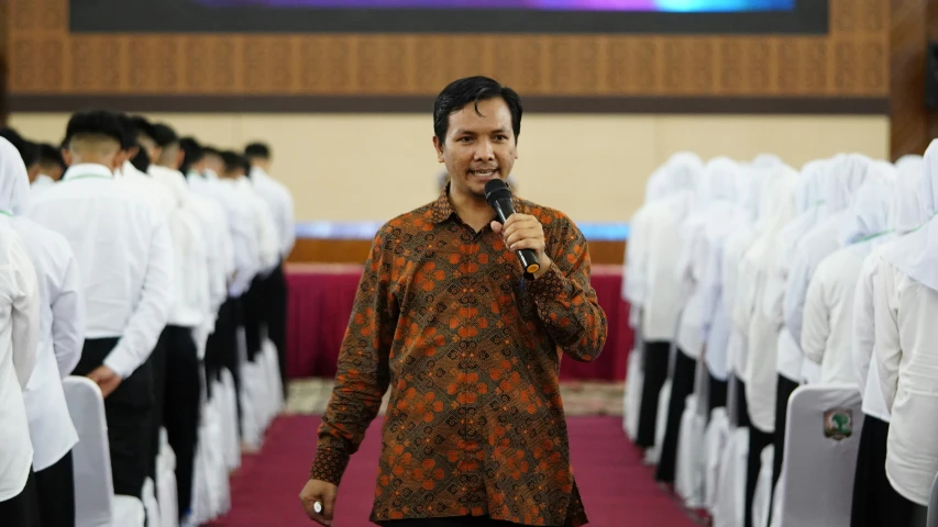 a man standing in front of white people with microphone