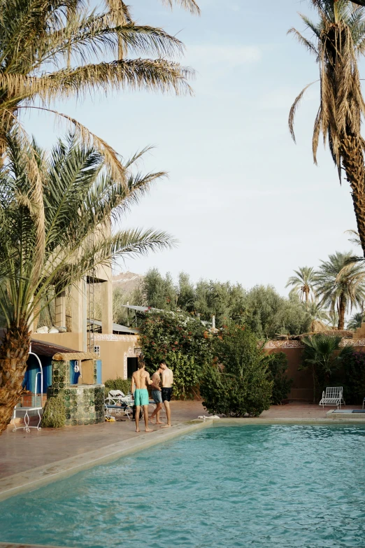 two people walk next to a pool in the desert