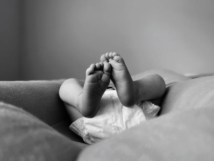 a small infant baby laying on top of a bed