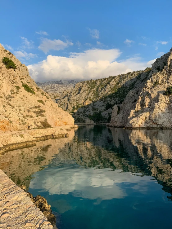 a body of water with mountains and a sky