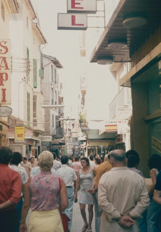 a group of people walk down a narrow alley