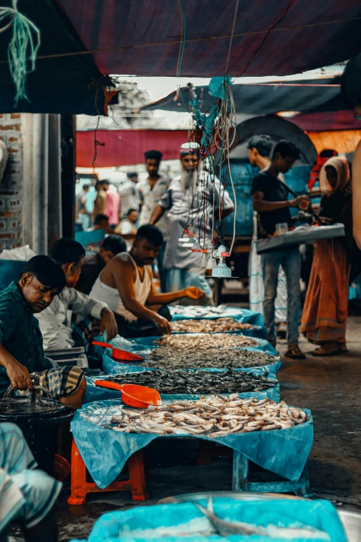 a large group of people standing around in front of food