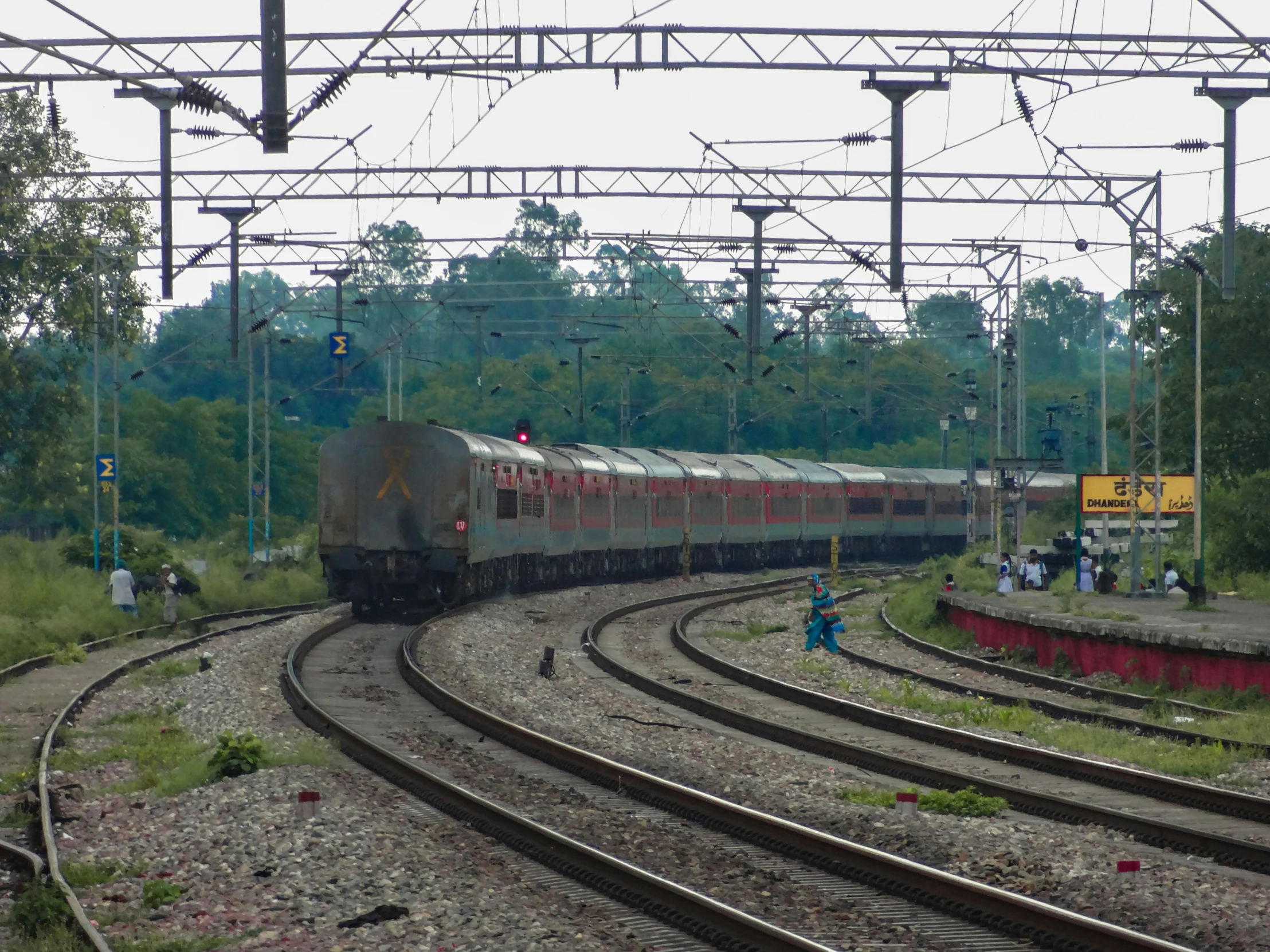 a train on train tracks with people beside it