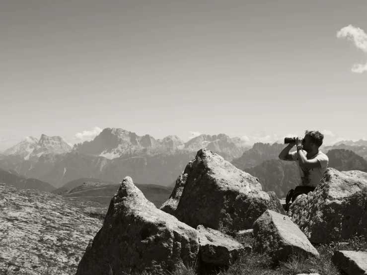 person on large rocks with camera taking pictures