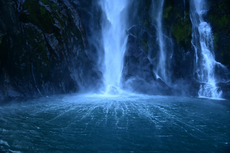 the large waterfall is very tall and has blue water