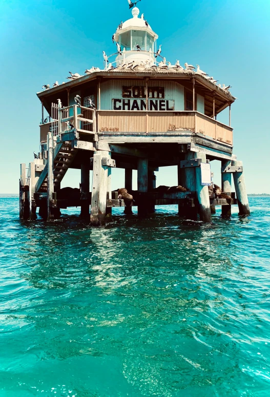 a dock with a small building at the top in the ocean