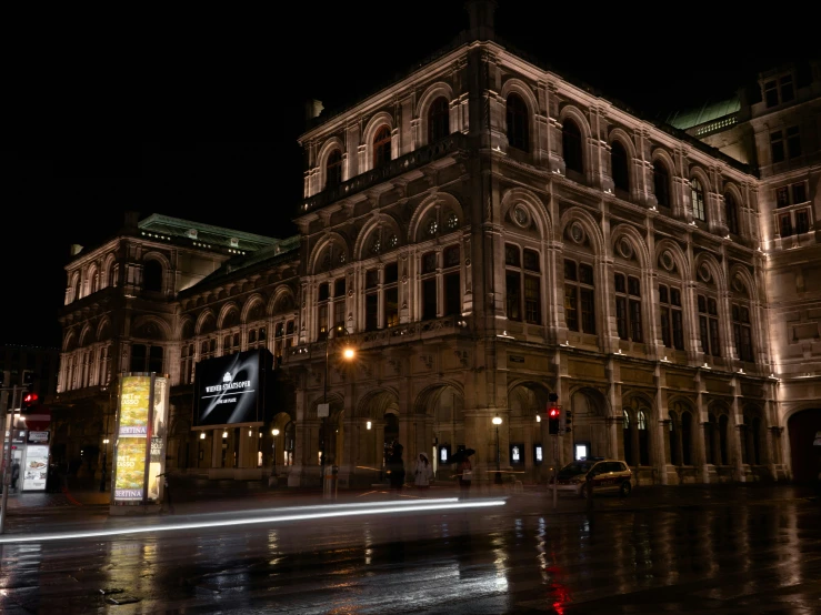 a large building lit up at night by street lights