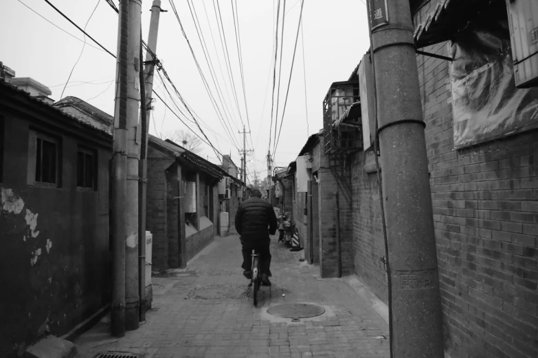 a person is riding a bicycle down a cobblestone street