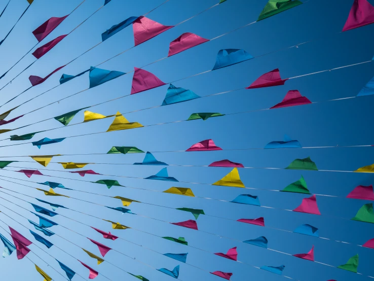 brightly colored flags flying against the blue sky