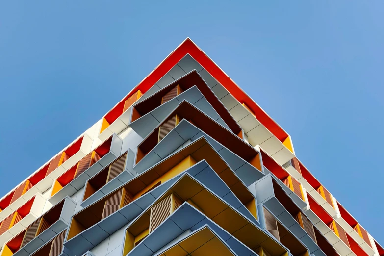 a very tall building with red, orange and yellow windows