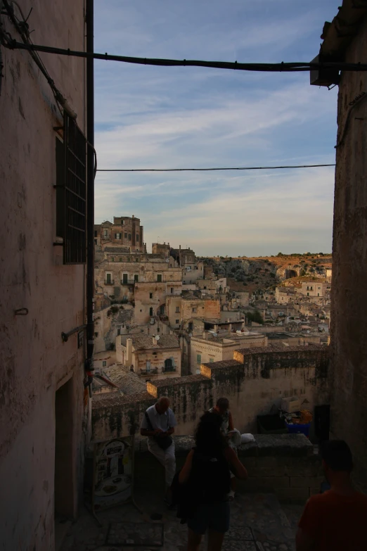 people are standing in a tunnel looking at an old city