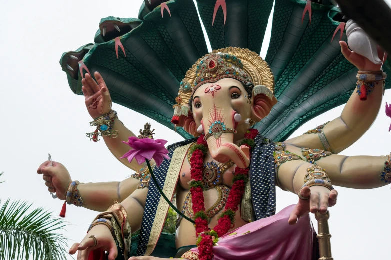 a statue of an indian woman dressed in pink and green