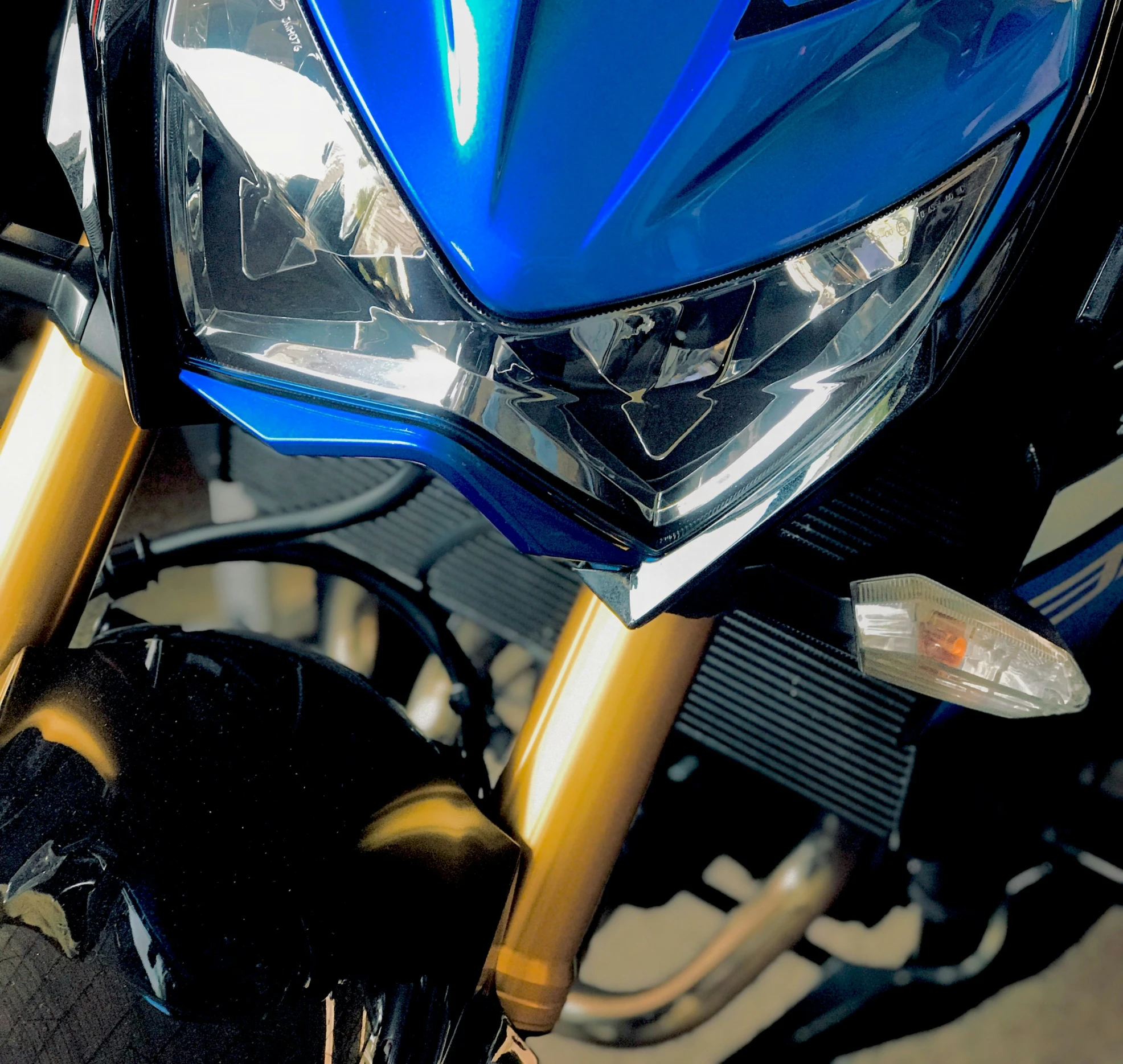 a blue motor cycle is parked at a street