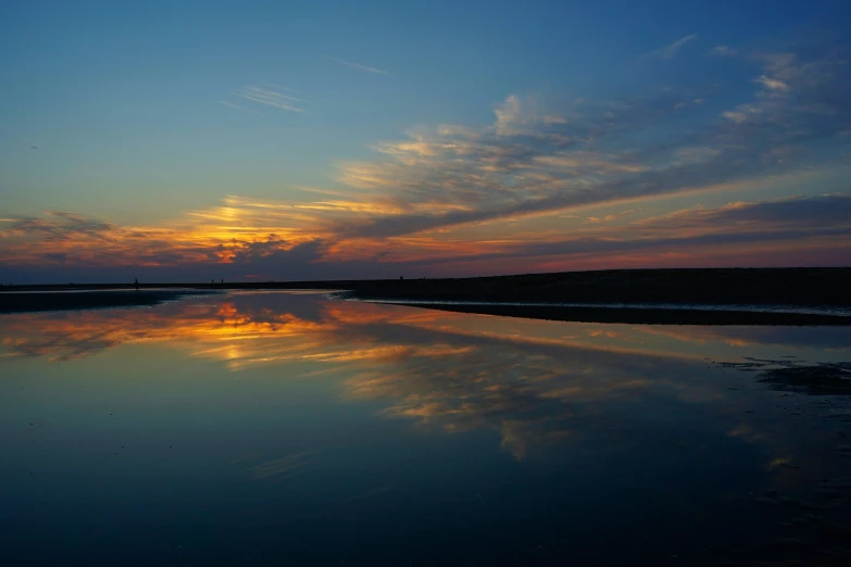 a beautiful sunset reflected in the calm water