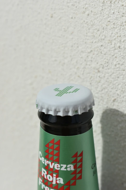 a green bottle with a white lid on a concrete surface