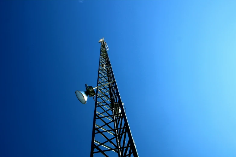 a black tower stands under a blue sky