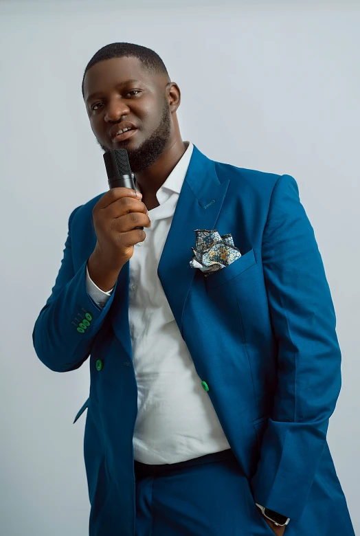 an african american man in a blue suit holding a microphone