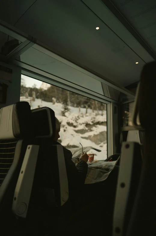 the inside of a bus with a small amount of people sitting next to it