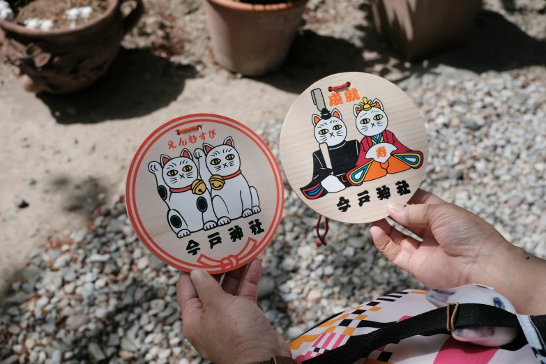 two people holding up small animal plates in their hands