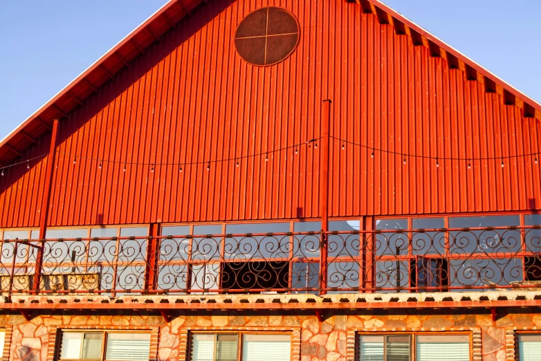 an orange building with a large arched doorway and a decorative balcony