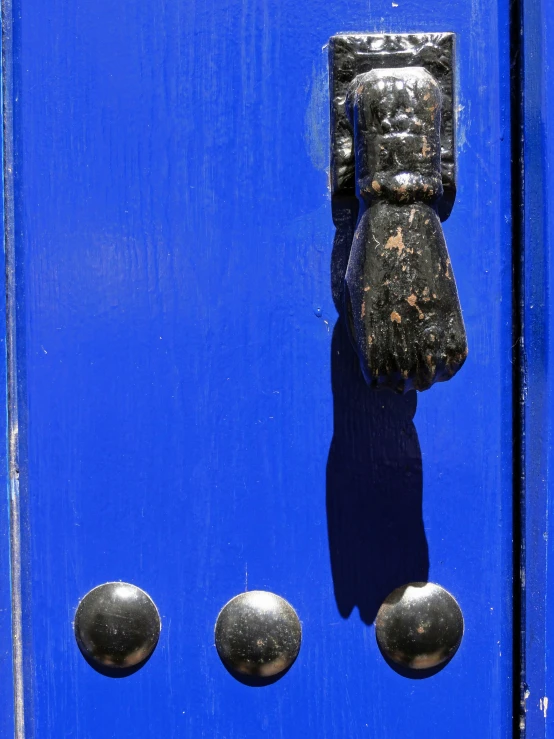 a metal handle on a blue door that is made to look like it has three s