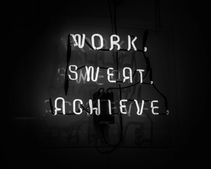 a neon sign is lit in the dark with words that read work, sweat eat achieve