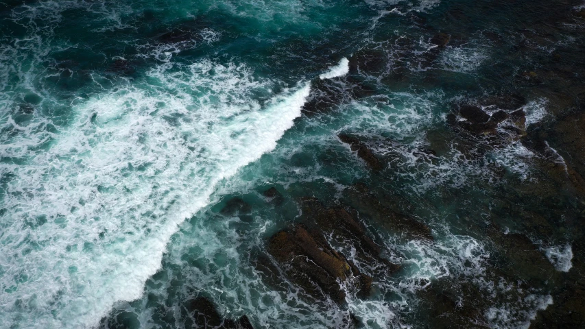 view from the air looking down at the crashing ocean