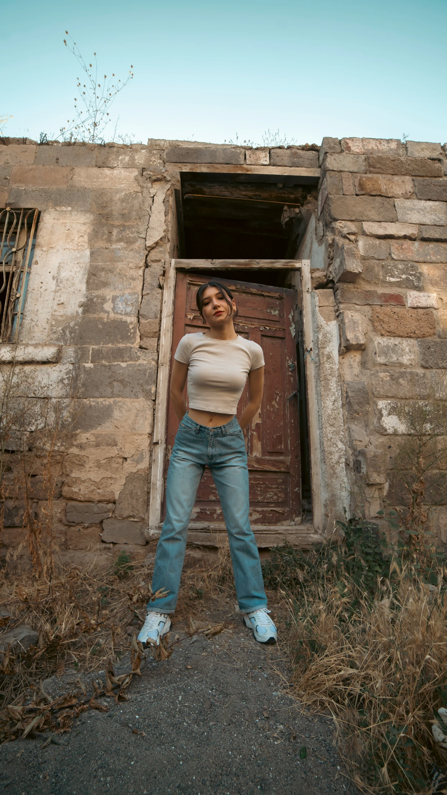 a girl standing in front of a door on her knees