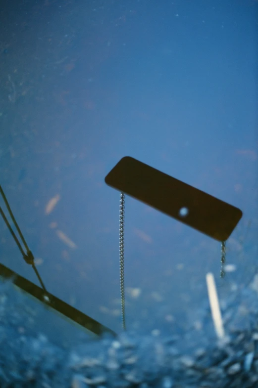 a strange object floating in a dle with a metal chain on it