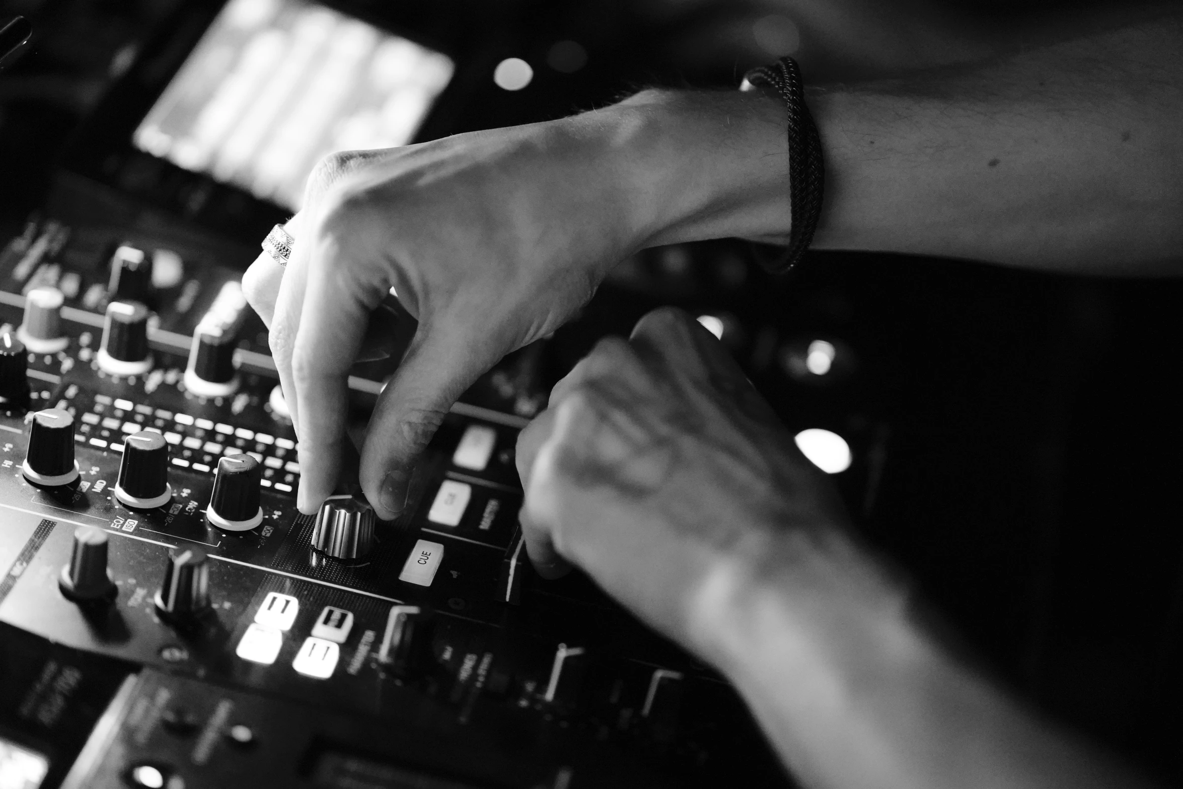 a man playing some musical controls in front of two hands