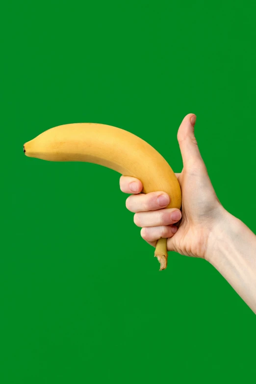 a person holding a banana over their left hand