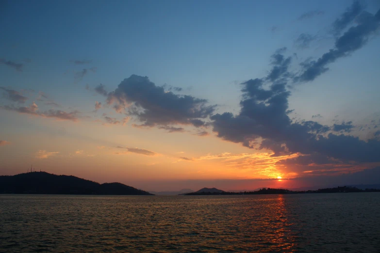 sunset on water with mountains in the background