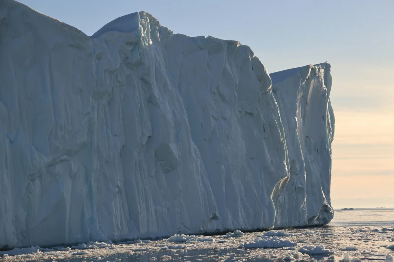 an iceberg in the foreground with some rocks sticking out