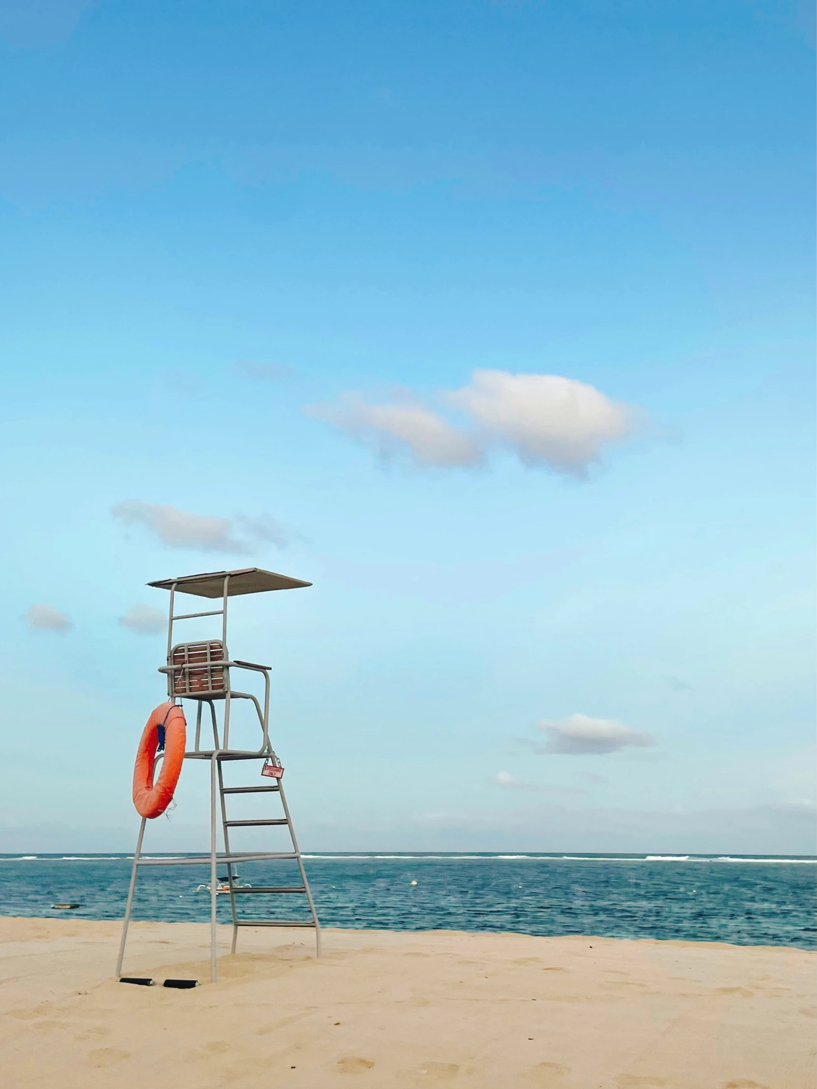 a lifeguard tower on the beach with an orange float