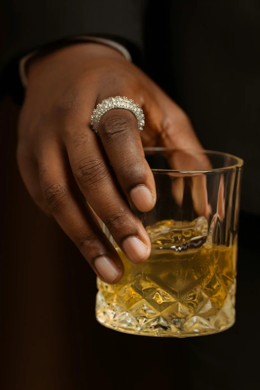 a hand holding a glass filled with liquid