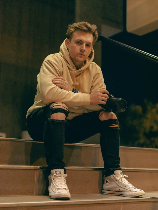 a person sitting on steps holding his hand behind his neck