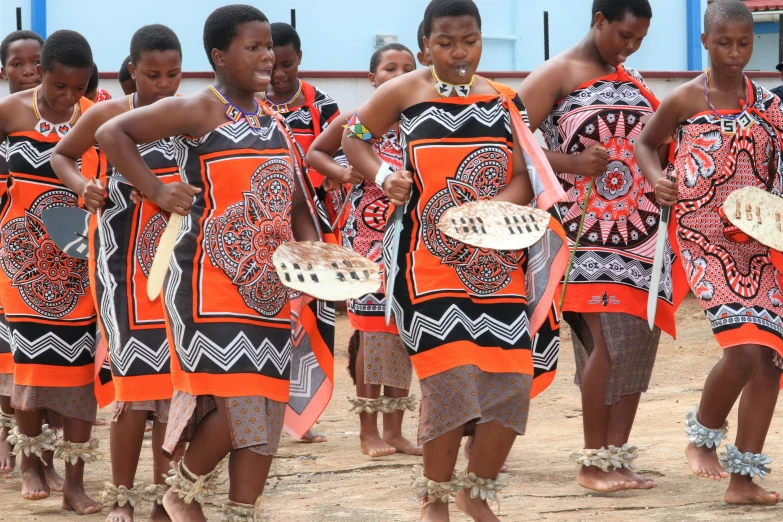 group of women wearing tribal dress dance and hold plates