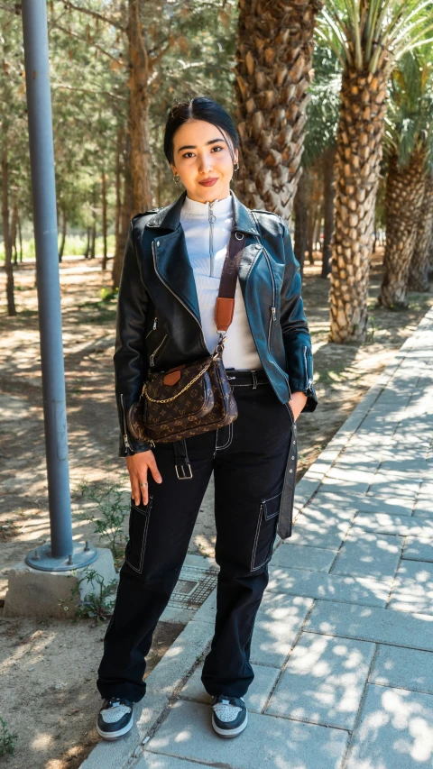 a woman is posing on a sidewalk