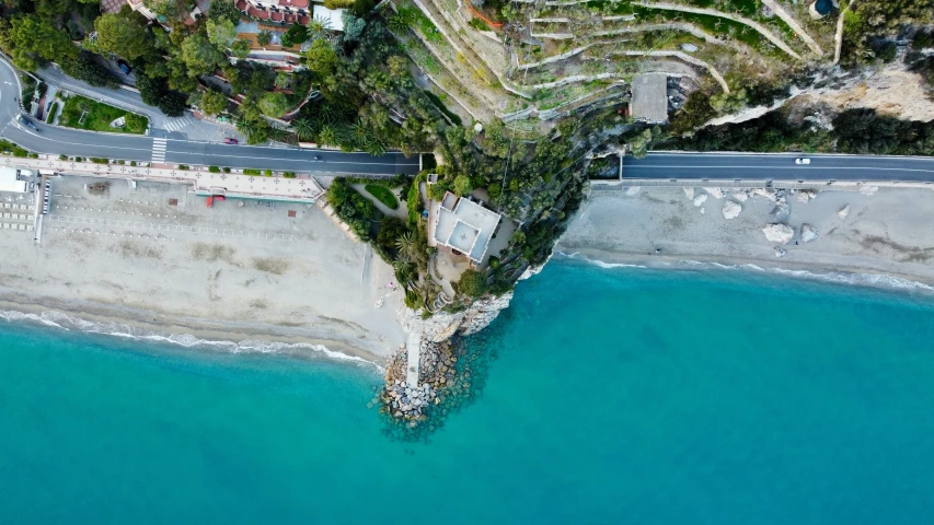 an aerial view of a winding road next to the ocean