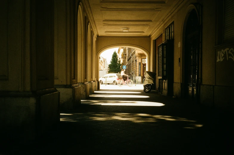 a dark hallway with an archway leading to a park