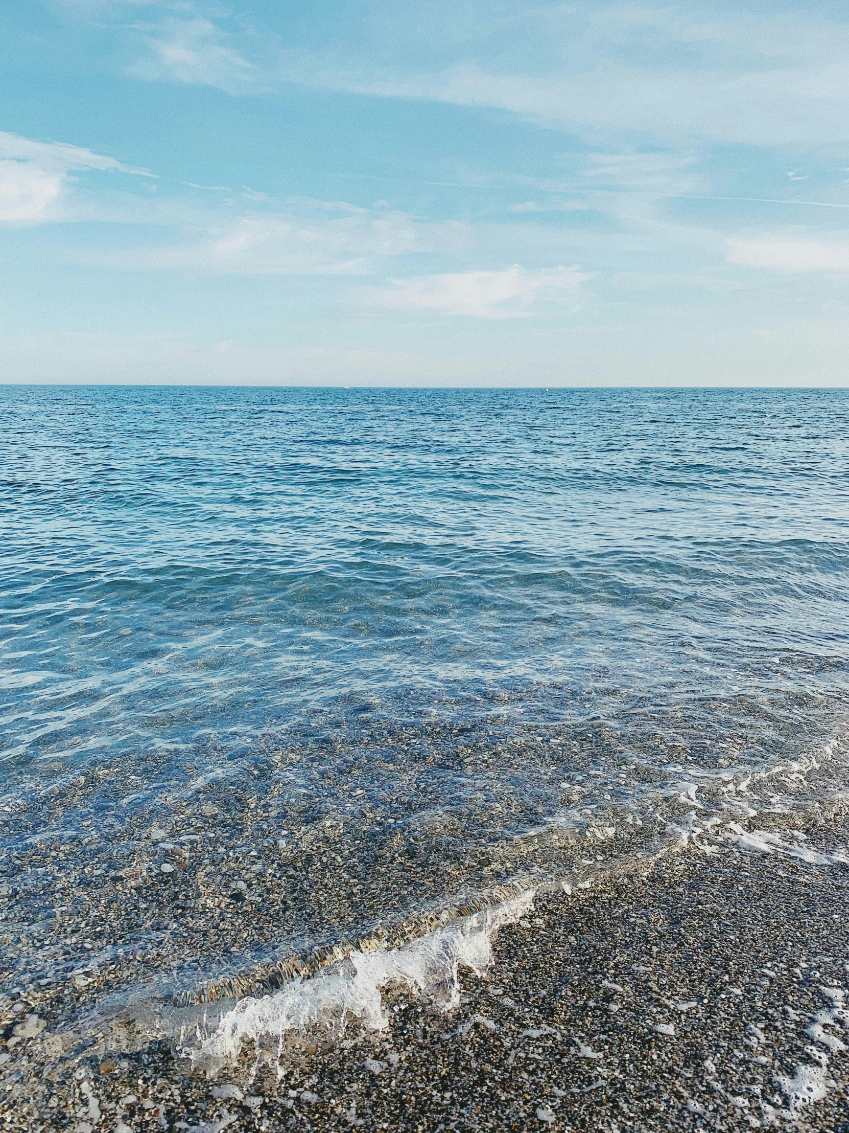 a blue ocean with waves coming in to the shore