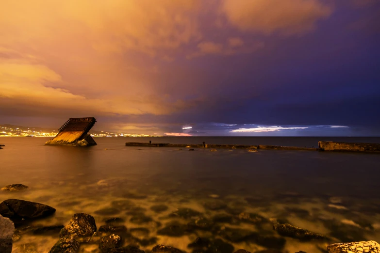 the rock shore next to the water has a small boat in it