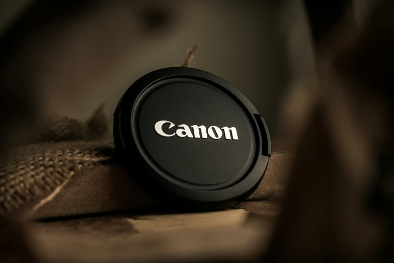 a black canon lens cap on a brown jacket