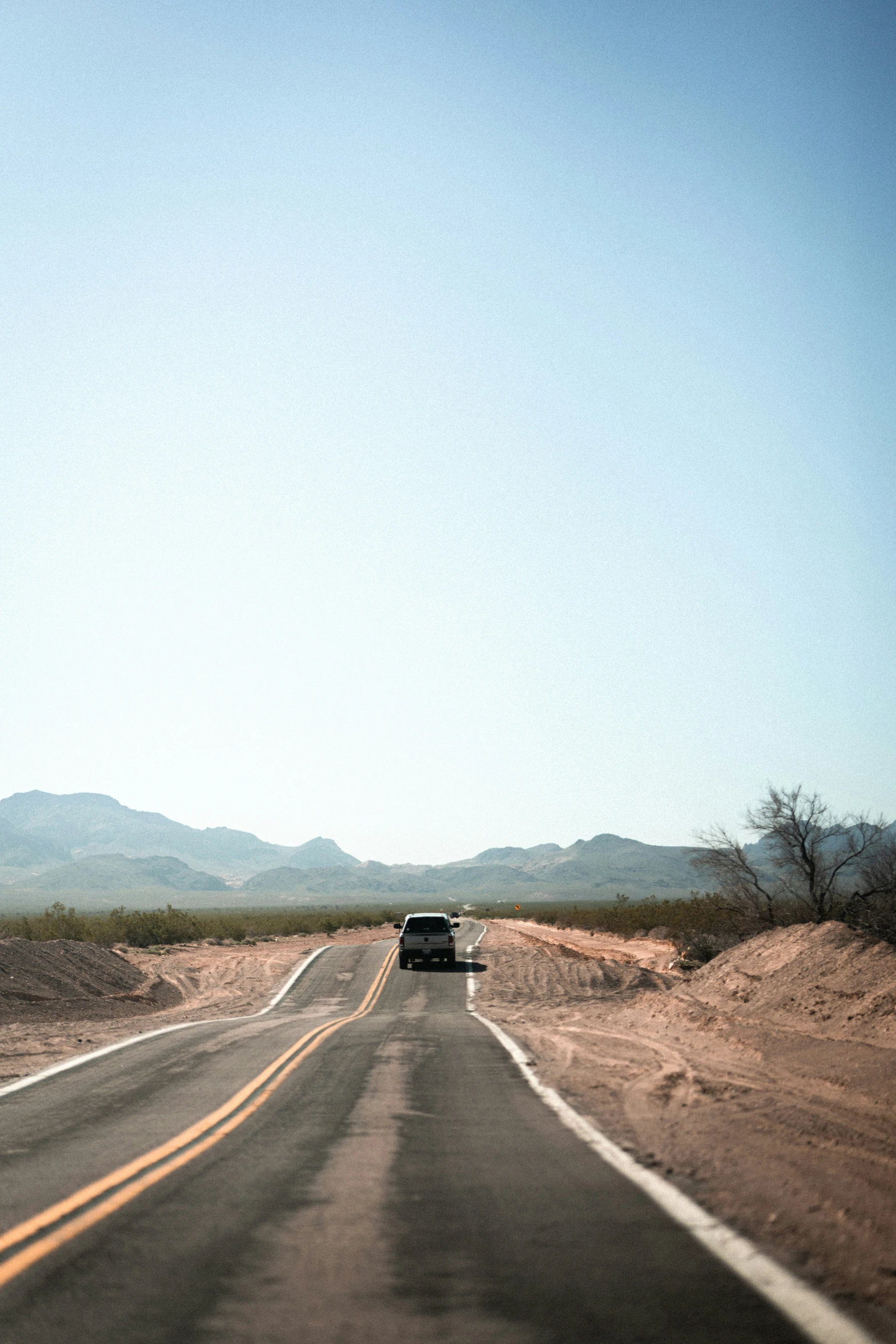 a white van driving down a road near a desert