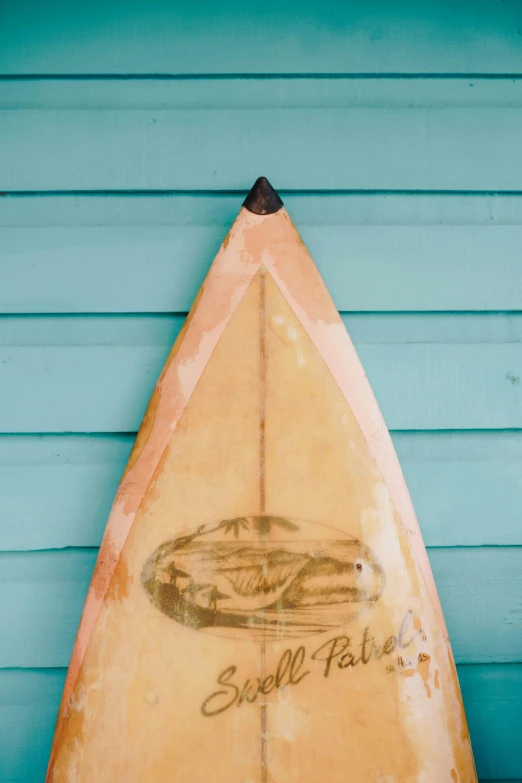 a surfboard propped against a wooden blue wall