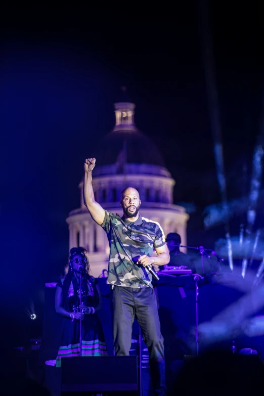 the man is singing in front of a band