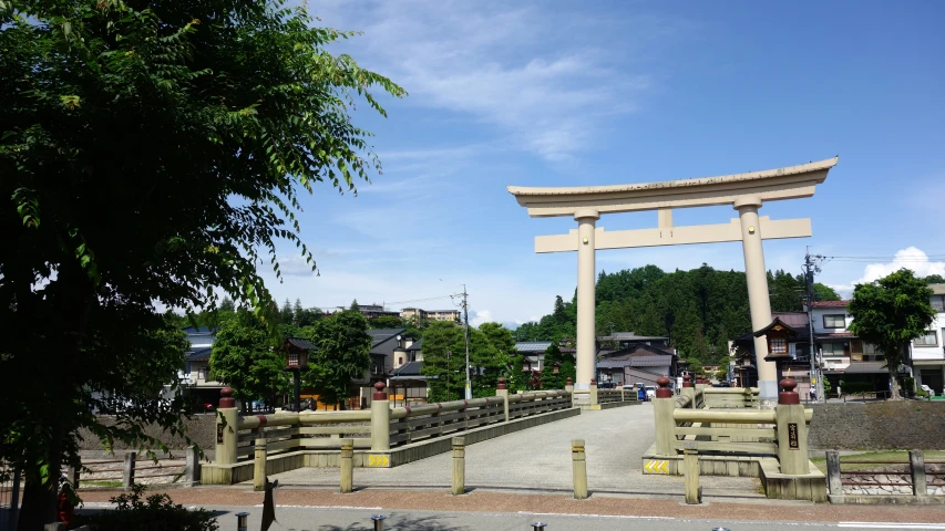 a japanese gate next to trees and a sidewalk